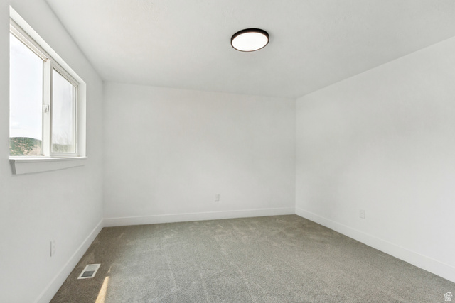 62 South Clark Lane Elk Ridge, UT 84651 - Photo 13 of 30 Primary bedroom featuring a double-pane window, flush-mount ceiling light, white walls, white baseboards, and gray carpeting