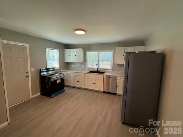 a kitchen with stainless steel appliances a refrigerator sink and cabinets