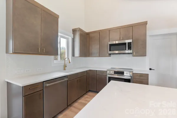 a kitchen with a sink and steel appliances