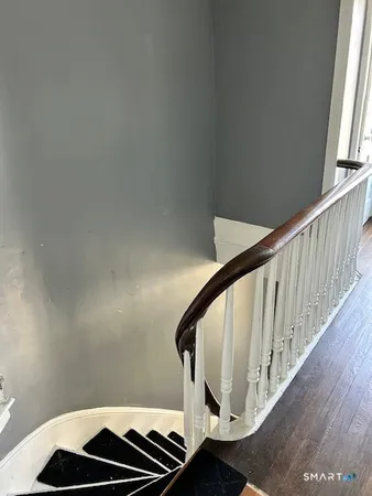 a view of staircase with railing and white walls