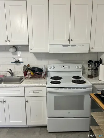 a kitchen with white cabinets and white appliances