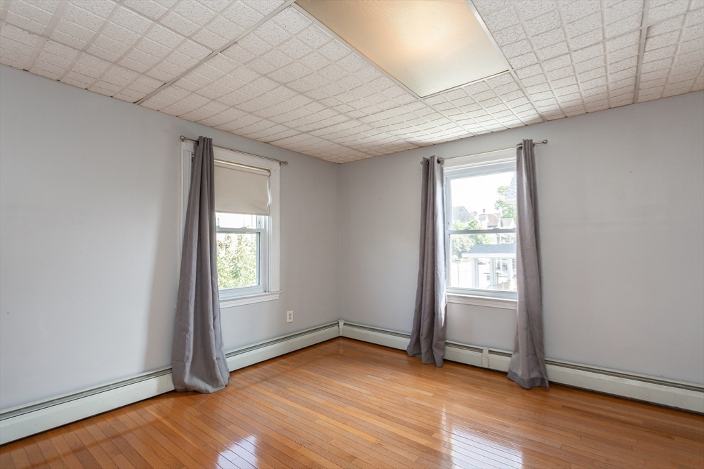 724 High Street Fall River, MA 02720 - Photo 20 of 39 an empty room with wooden floor and windows
