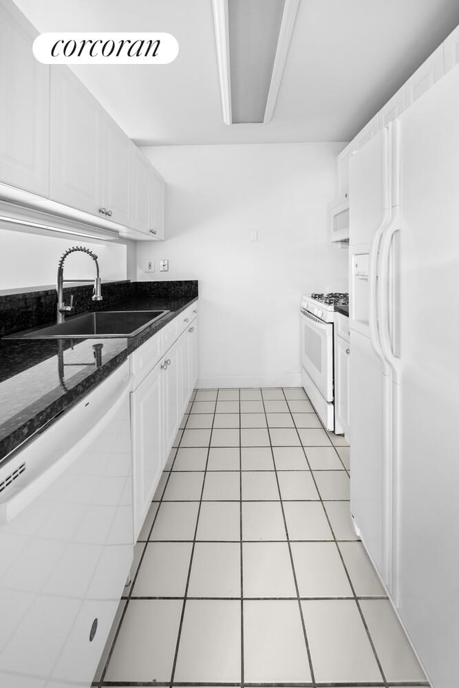 404 East 76th Street, Unit 3D Manhattan, NY 10021 - Photo 10 of 14 a kitchen with granite countertop a sink and a stove