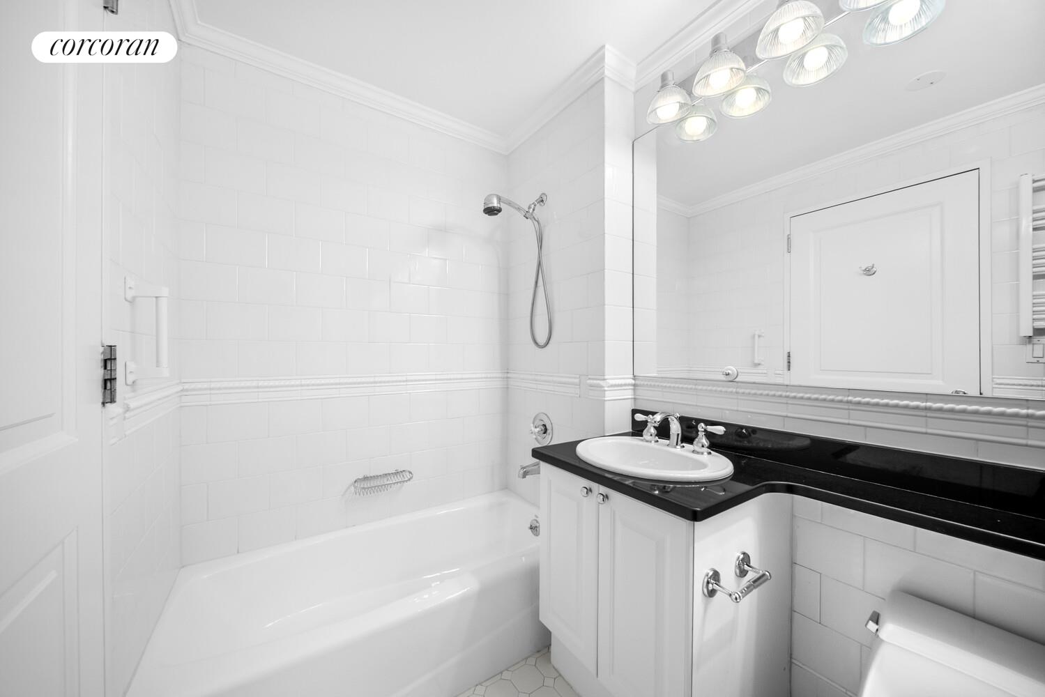 404 East 76th Street, Unit 3D Manhattan, NY 10021 - Photo 11 of 14 a bathroom with a granite countertop sink a large mirror and shower