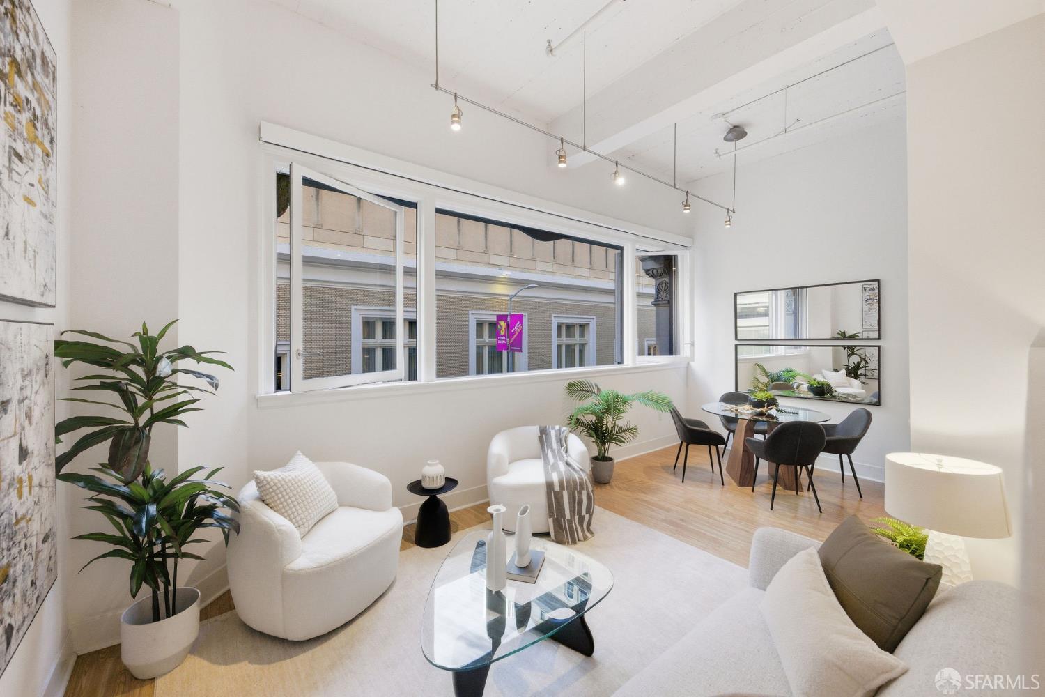 74 New Montgomery Street, Unit 211 San Francisco, CA 94105 - Photo 13 of 22 a living room with furniture flowers and a large window