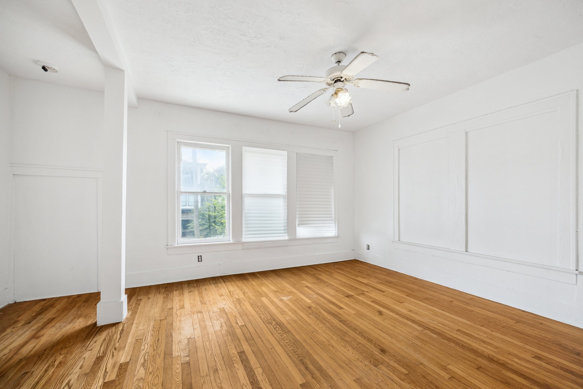 918-920 Peden Street Houston, TX 77006 - Photo 11 of 13 an empty room with wooden floor fan and windows