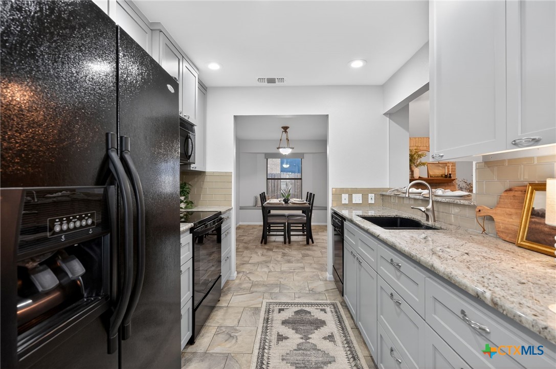 1719 Ridgeway Drive Temple, TX 76502 - Photo 6 of 28 Galley kitchen with granite, range, microwave, dishwasher, refrigerator and pantry