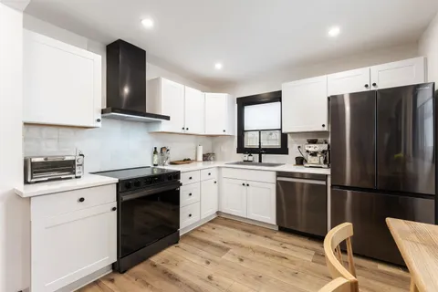 a kitchen with stainless steel appliances granite countertop a refrigerator stove and sink
