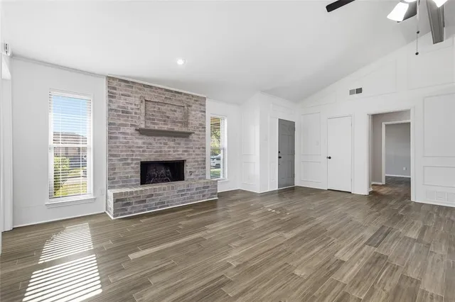 a view of an empty room with a fireplace and a window