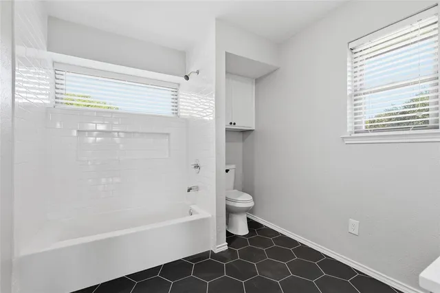 a bathroom with a toilet and a bathtub