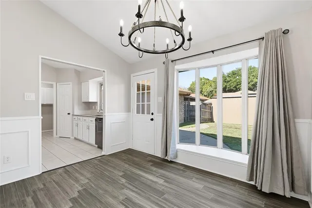 a view of a big room with wooden floor and windows