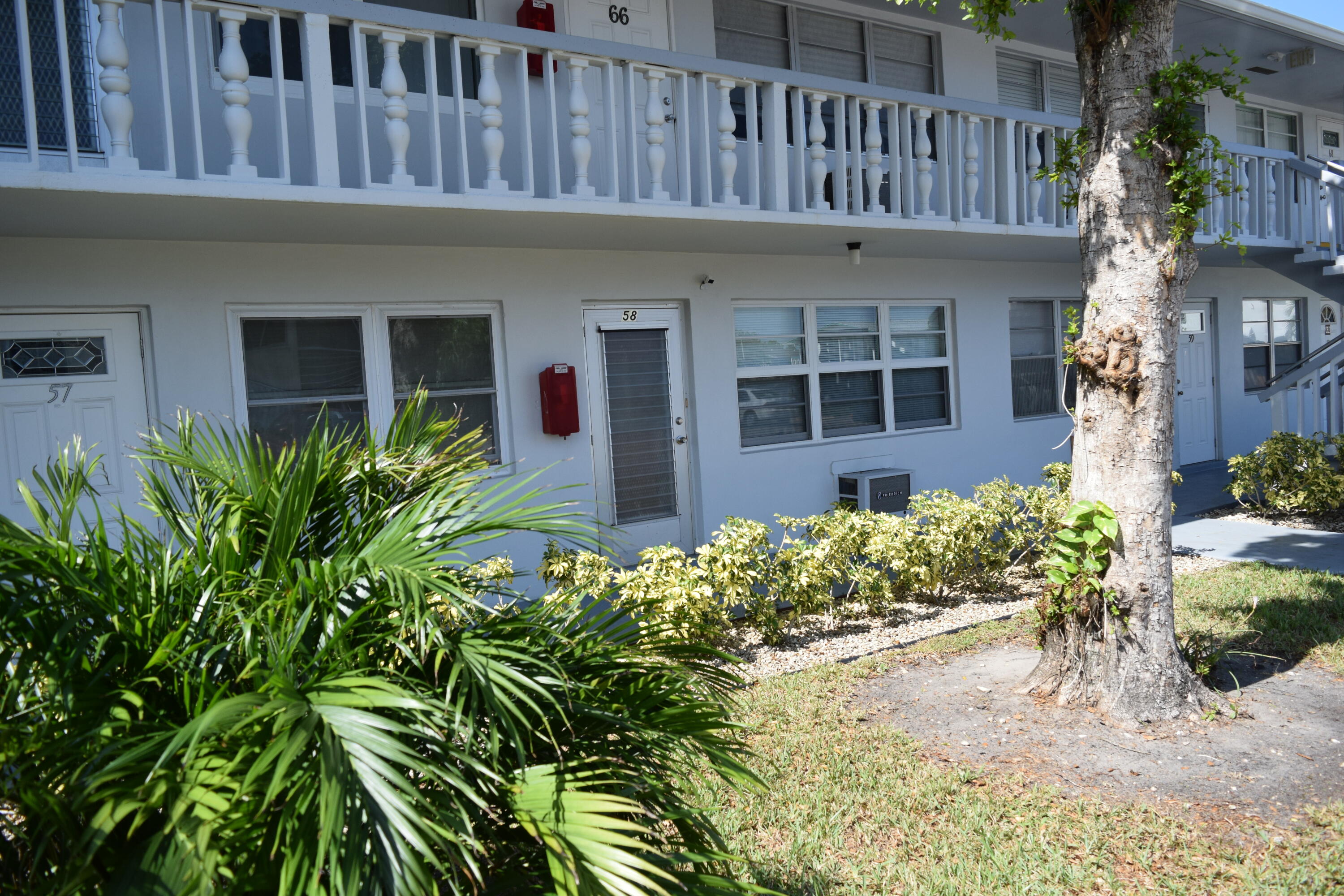 58 Sussex C, Unit C West Palm Beach, FL 33417 - Photo 19 of 22 a front view of a house with a garden