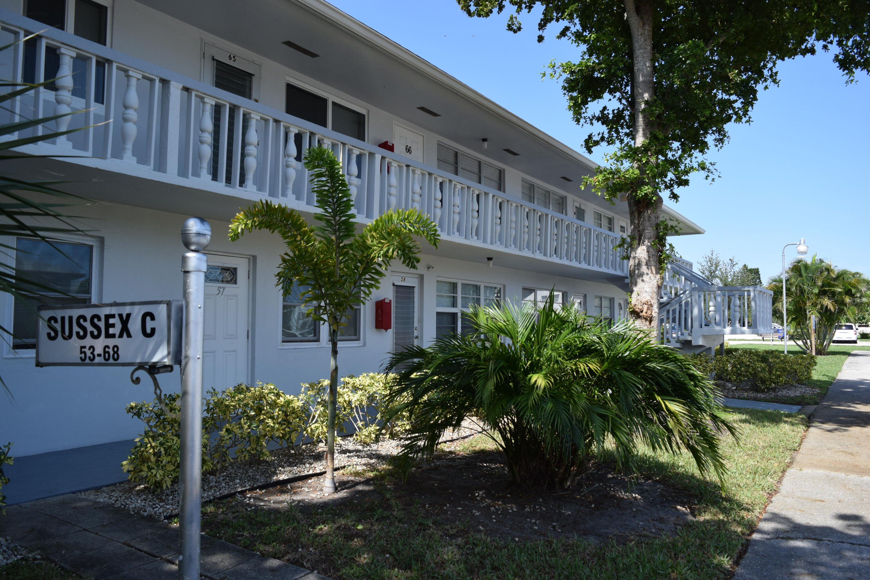 58 Sussex C, Unit C West Palm Beach, FL 33417 - Photo 20 of 22 a front view of a building with garden