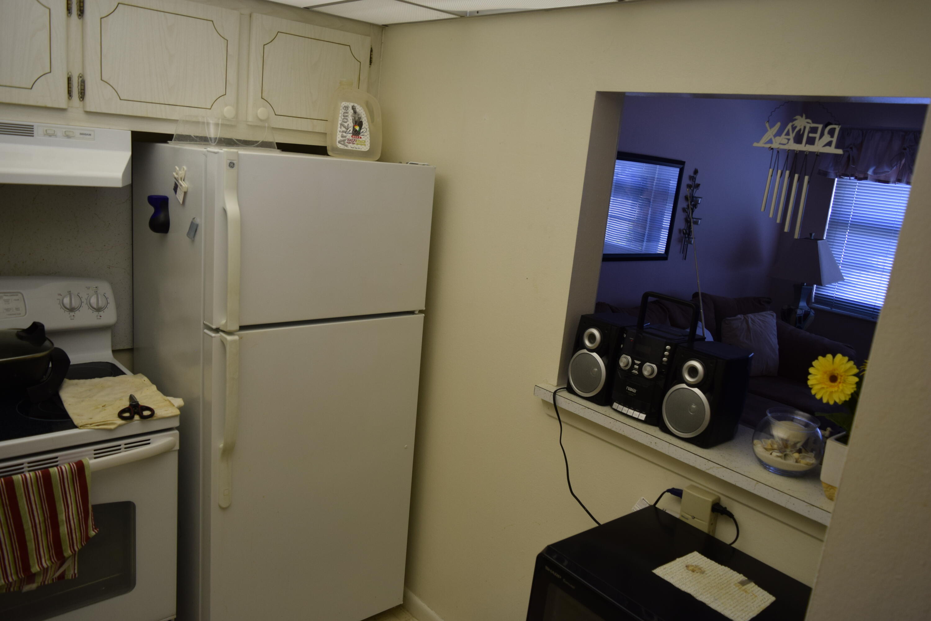 58 Sussex C, Unit C West Palm Beach, FL 33417 - Photo 3 of 22 a kitchen with a refrigerator and cabinets