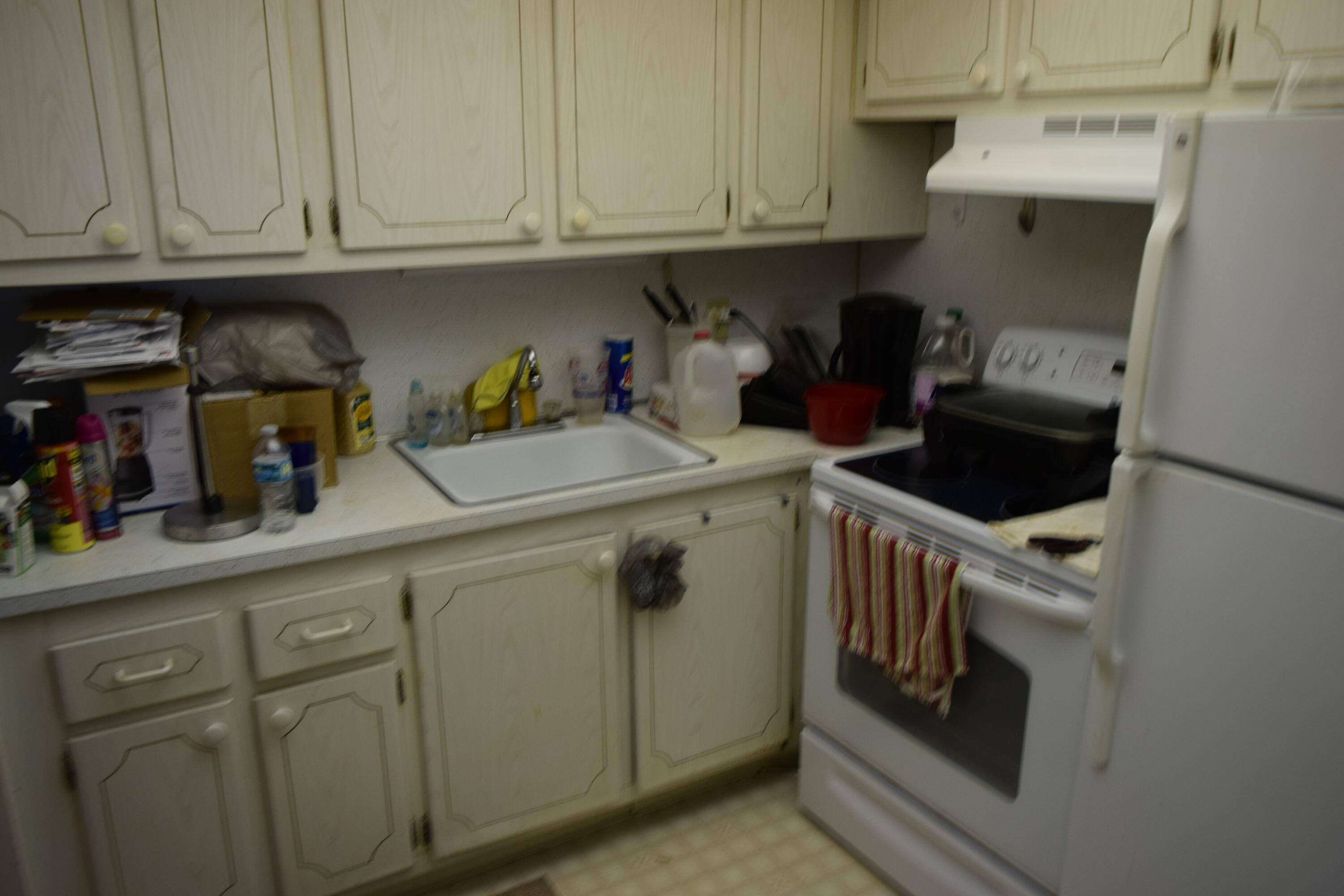 58 Sussex C, Unit C West Palm Beach, FL 33417 - Photo 6 of 22 a kitchen with stainless steel appliances granite countertop a sink and cabinets