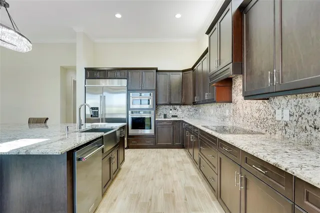 a kitchen with stainless steel appliances granite countertop a sink stove and cabinets
