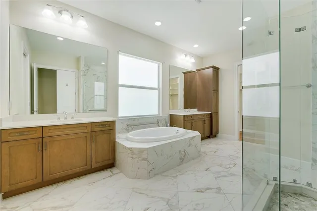 a bathroom with a granite countertop sink a toilet a mirror and bathtub