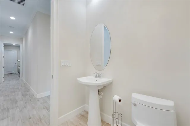 a bathroom with a sink a toilet and a mirror