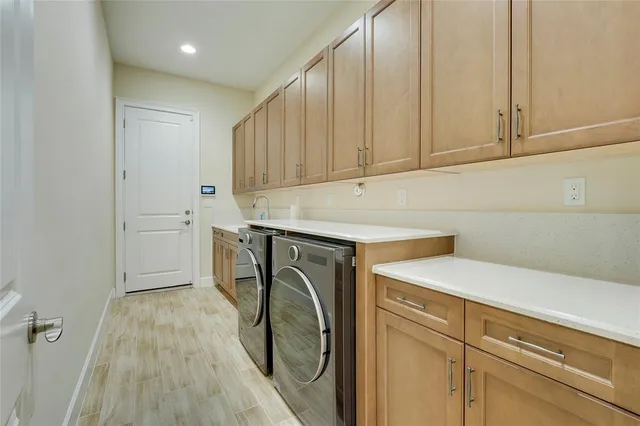 a utility room with cabinets washer and dryer