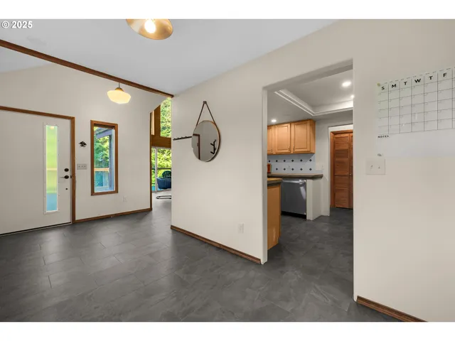 a view of a hallway with an entryway and livingroom with furniture