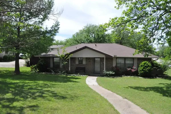 a front view of a house with yard and green space