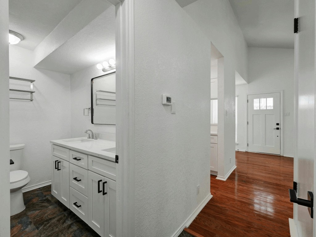 913 Sirocco Drive, Unit A & B Austin, TX 78745 - Photo 20 of 39 a spacious bathroom with a granite countertop sink a toilet and a mirror