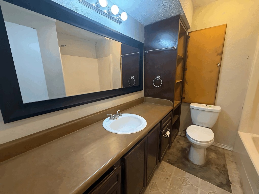 913 Sirocco Drive, Unit A & B Austin, TX 78745 - Photo 30 of 39 a bathroom with a granite countertop sink toilet and mirror