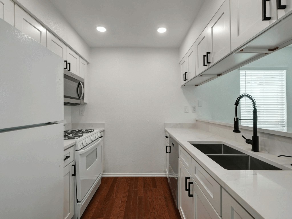 913 Sirocco Drive, Unit A & B Austin, TX 78745 - Photo 4 of 39 a kitchen with stainless steel appliances granite countertop a sink a stove and a refrigerator