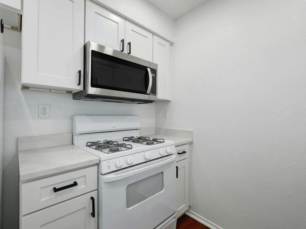 913 Sirocco Drive, Unit A & B Austin, TX 78745 - Photo 9 of 39 a kitchen with white cabinets stainless steel appliances and sink