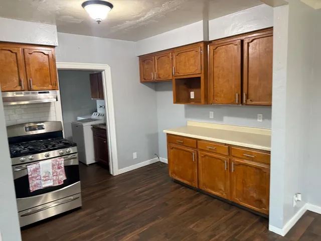 a kitchen with wooden floors and stainless steel appliances