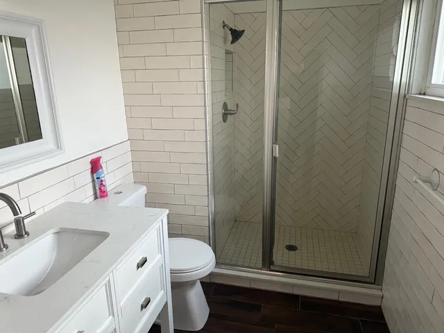 a bathroom with a sink a toilet and shower