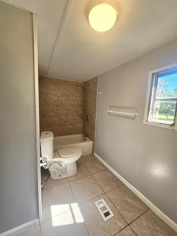a bathroom with a toilet a sink and a window