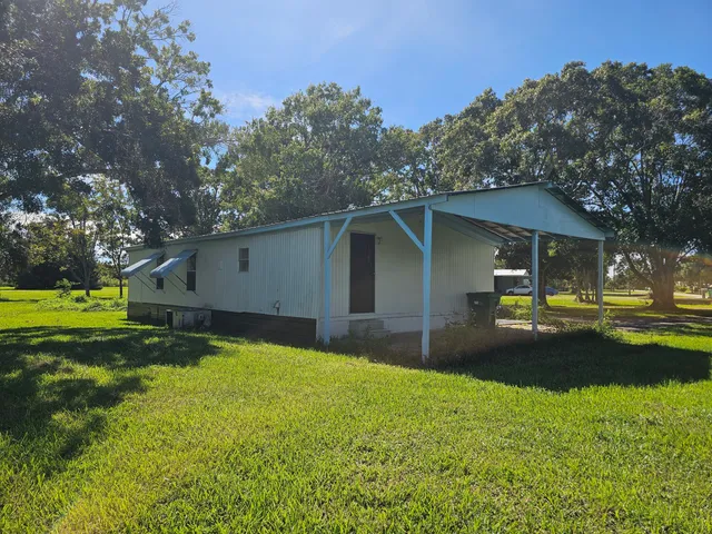 a view of a house with backyard and sitting area