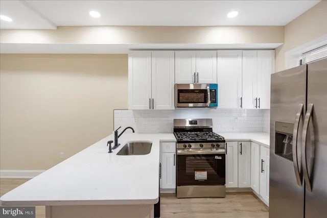 a kitchen with stainless steel appliances a refrigerator stove and microwave