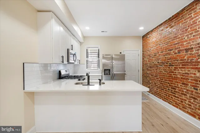 a bathroom with a granite countertop sink a mirror and shower