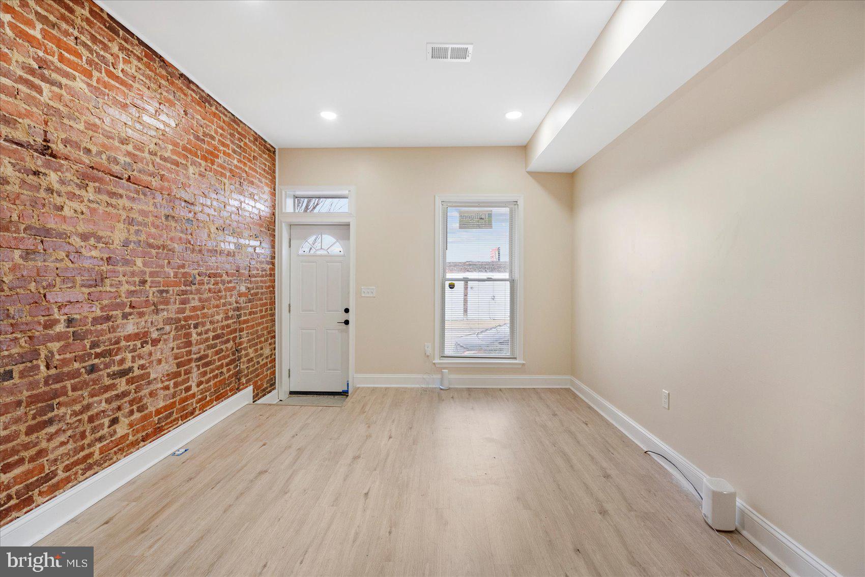 3205 Esther Place Baltimore, MD 21224 - Photo 25 of 32 a view of an empty room with wooden floor and a window