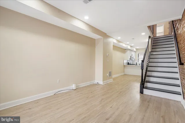a view of a hallway with wooden floor and entryway