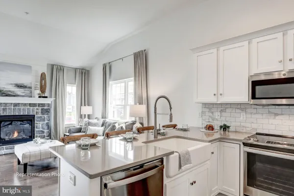 a view of a dining room with furniture a kitchen and chandelier