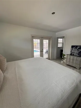 a bedroom with a bed and a large window