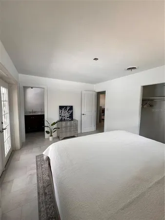 a large bed sitting in a bedroom next to a window
