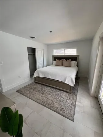 a large bedroom with a bed and a view of kitchen