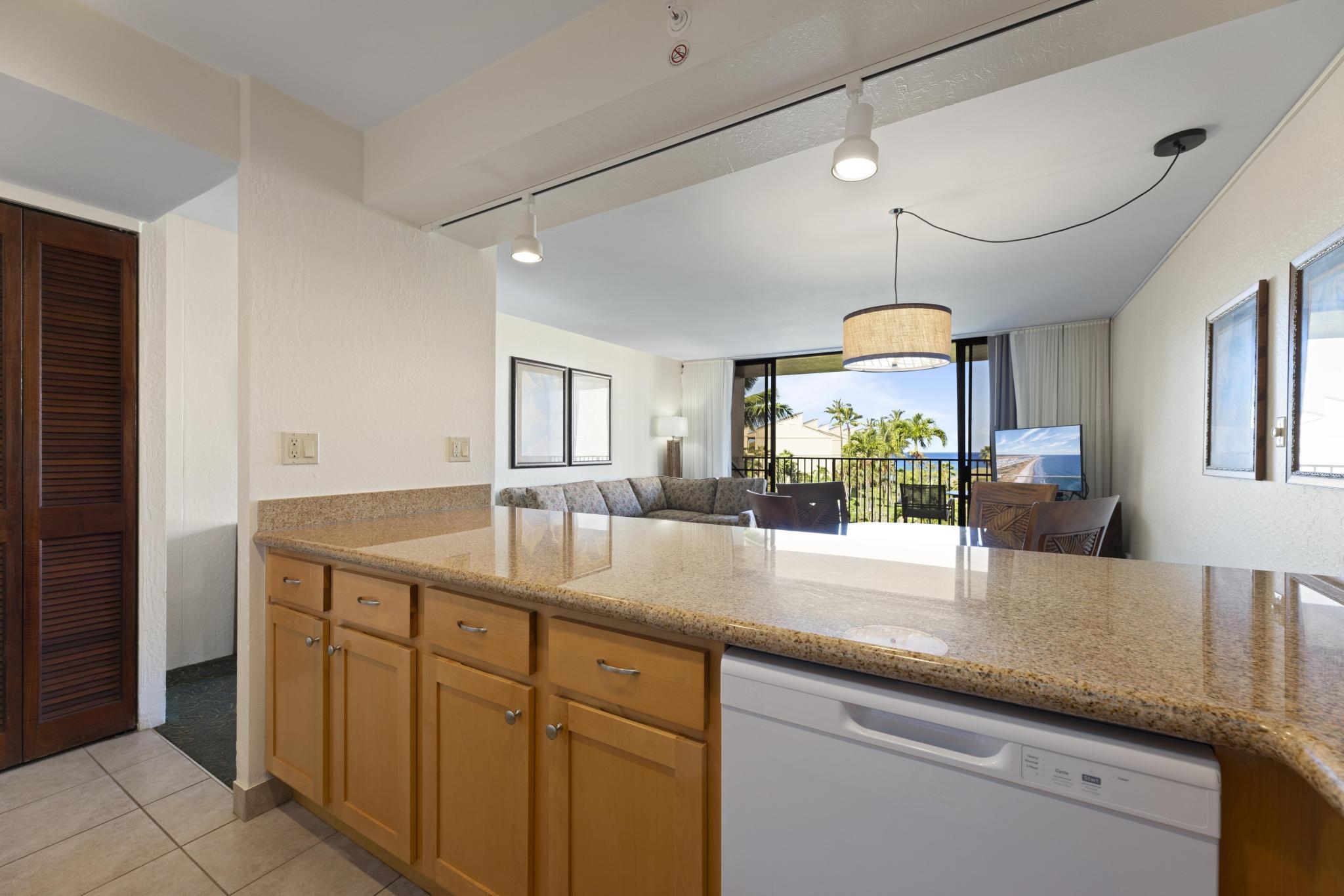 3445 Lower Honoapiilani Road, Unit 431 Lahaina, HI 96761 - Photo 8 of 32 a kitchen with kitchen island granite countertop a sink and a large window