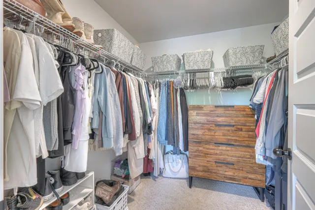 a view of walk in closet with clothes