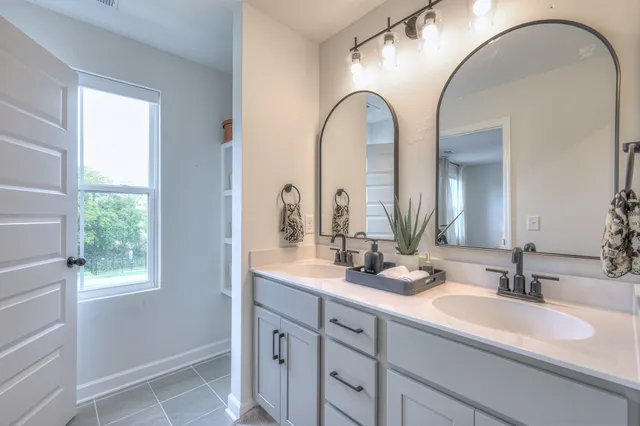 a bathroom with a double vanity sink and a mirror