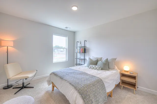 a bedroom with a bed chair and window
