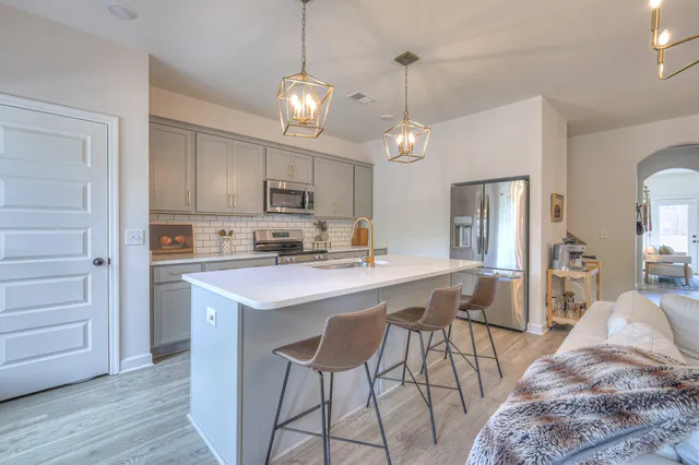 a kitchen with stainless steel appliances a stove a sink island and a refrigerator