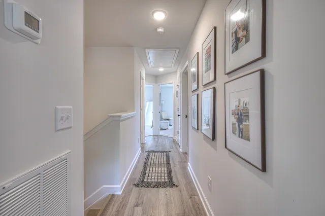 a view of a hallway with wooden floor and staircase