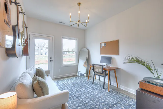 a living room with furniture a window and a potted plant