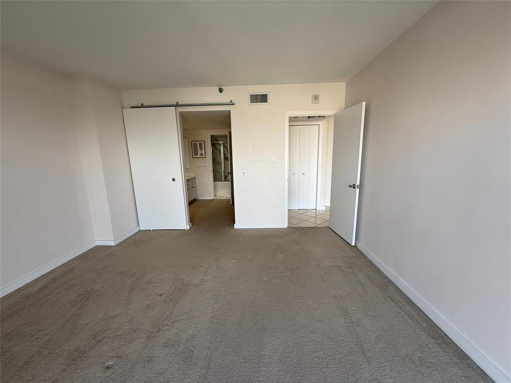 19707 Turnberry Way, Unit 7C Aventura, FL 33180 - Photo 13 of 40 a view of a big room with closet and wooden door