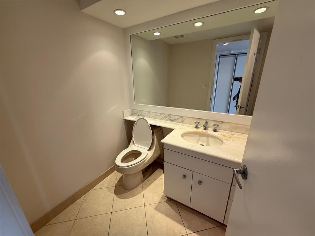 19707 Turnberry Way, Unit 7C Aventura, FL 33180 - Photo 19 of 40 a bathroom with a toilet sink and mirror